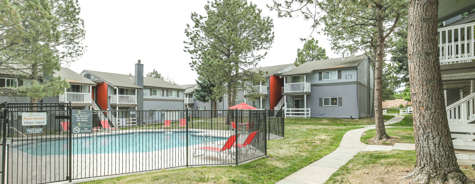 Landscaped grounds with a pool and fence