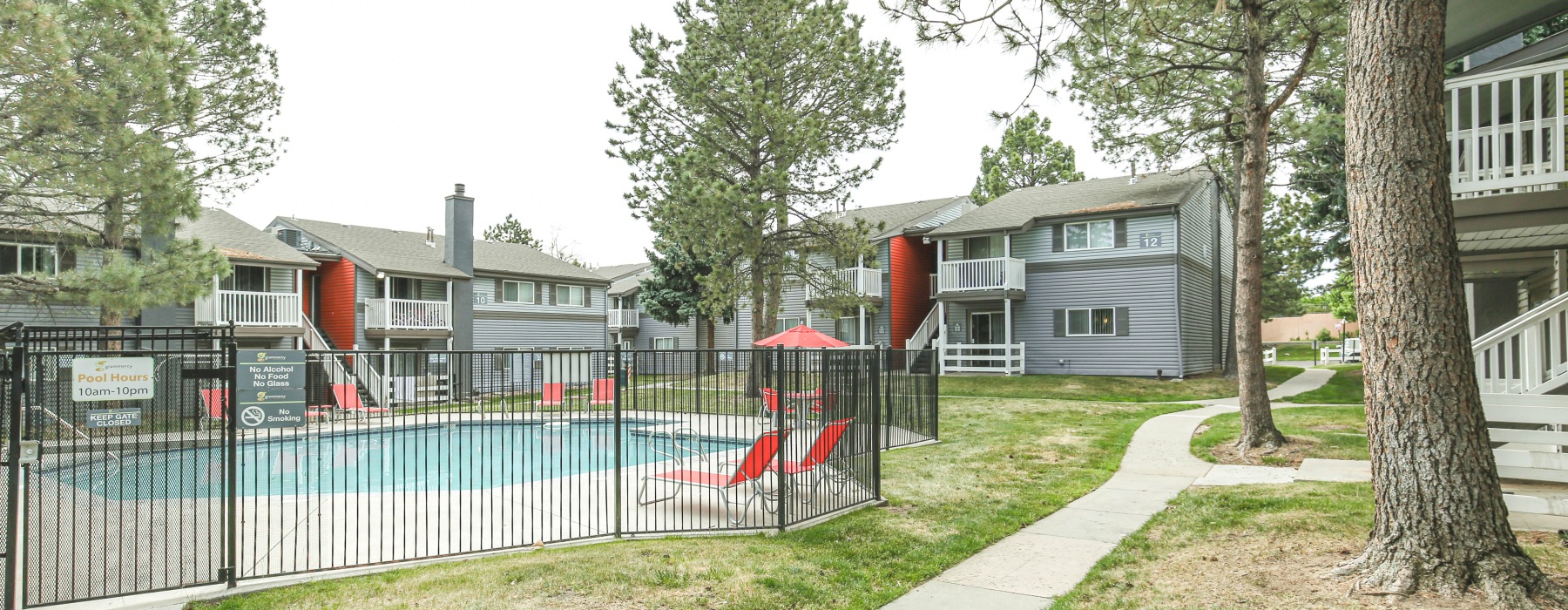 Landscaped grounds with a pool and fence