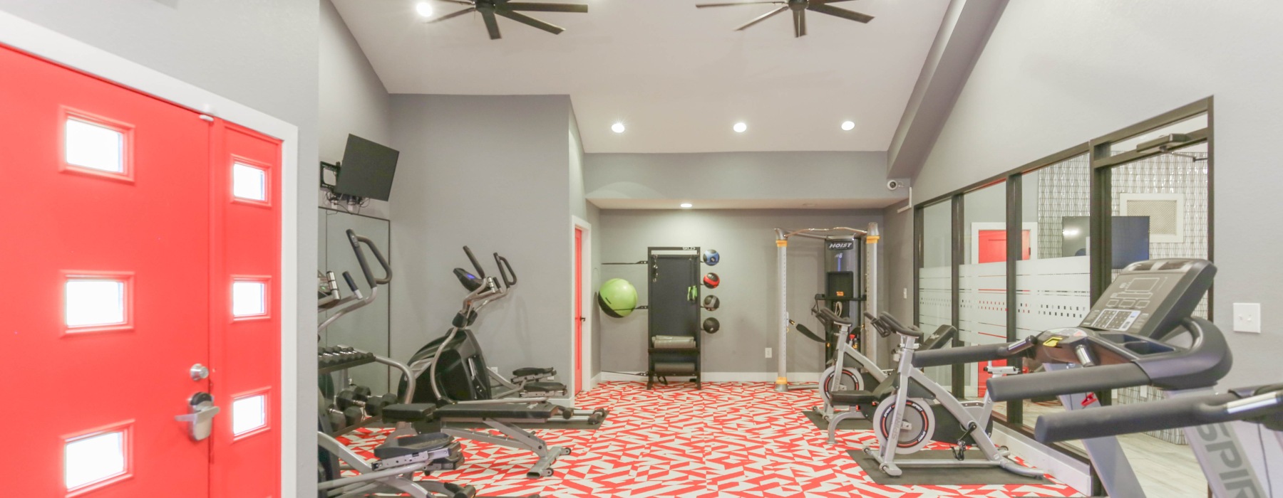 fitness room with workout equipment and pink door