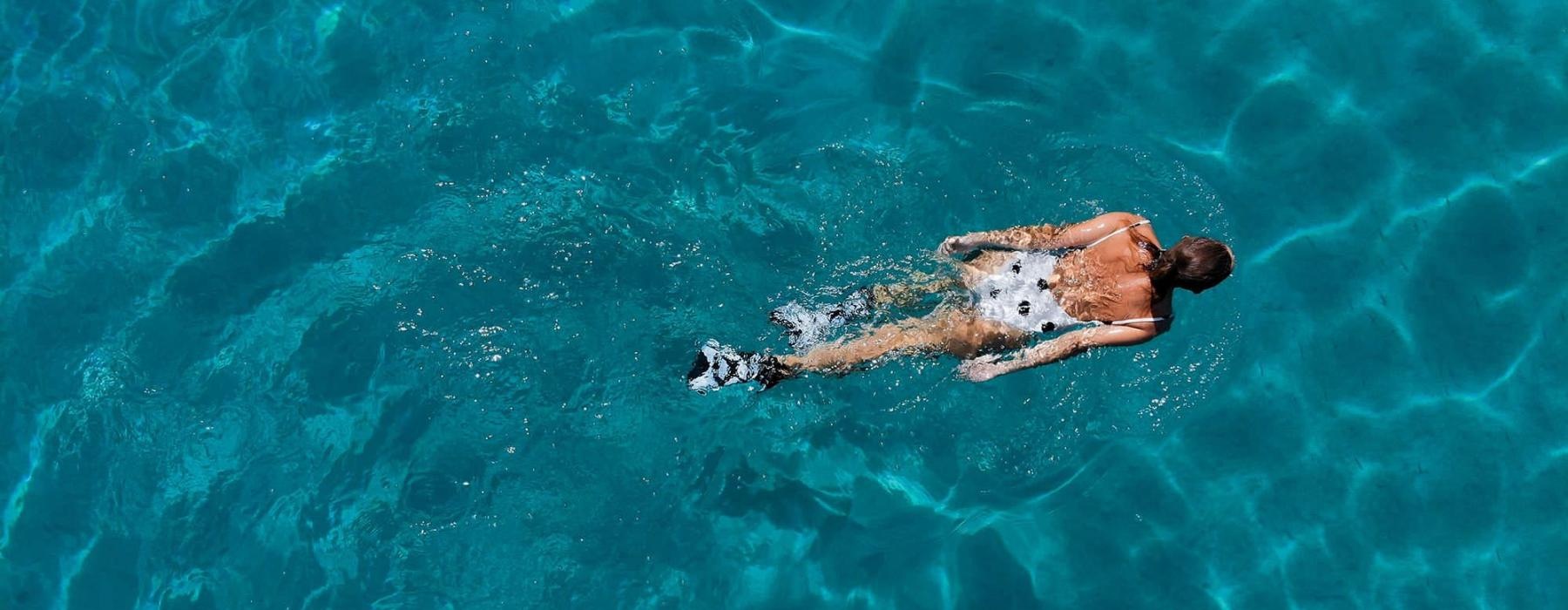 overhead shot of a woman swimming in a pool